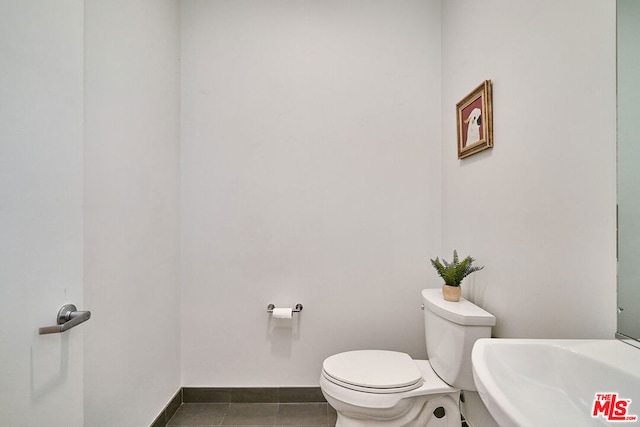 bathroom featuring toilet, sink, and tile patterned floors