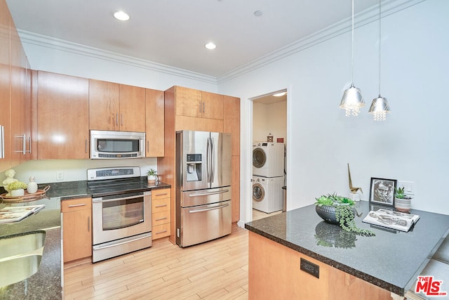 kitchen featuring pendant lighting, appliances with stainless steel finishes, stacked washing maching and dryer, light hardwood / wood-style flooring, and crown molding