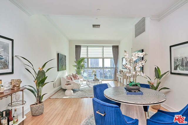 dining area with wood-type flooring and crown molding