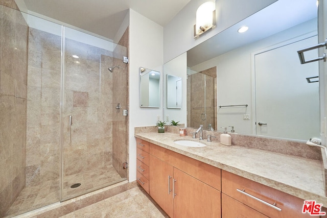 bathroom featuring vanity, tile patterned flooring, and a shower with door