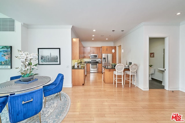 dining room featuring ornamental molding, light hardwood / wood-style floors, and sink