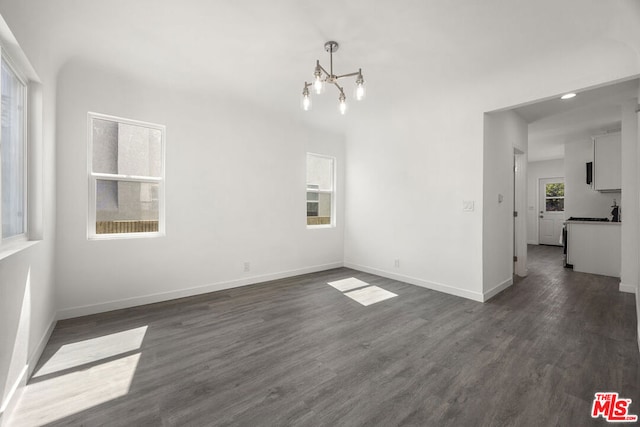 unfurnished dining area featuring dark wood-type flooring and a chandelier