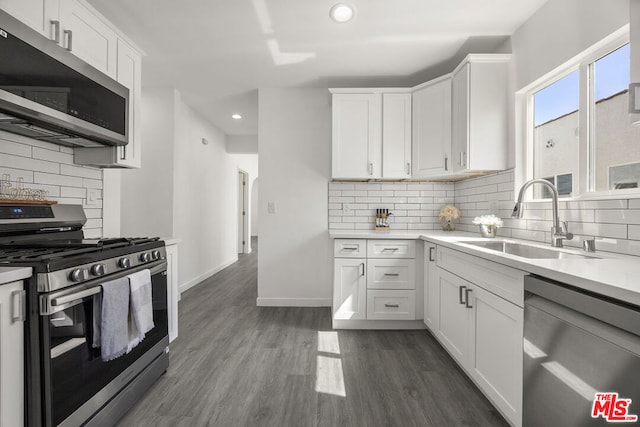 kitchen featuring white cabinets, dark hardwood / wood-style flooring, stainless steel appliances, tasteful backsplash, and sink