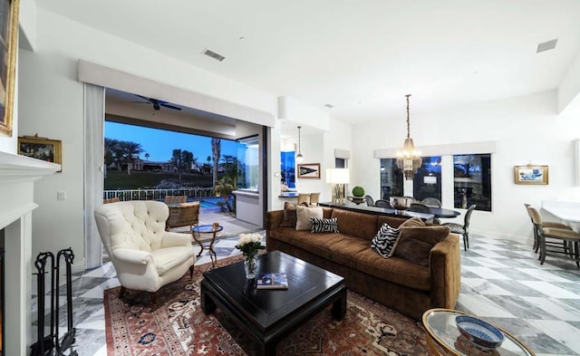 living room featuring ceiling fan with notable chandelier