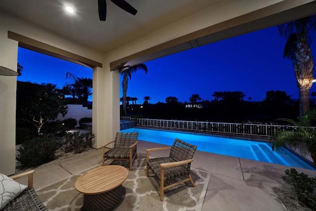 pool at twilight with ceiling fan and a patio