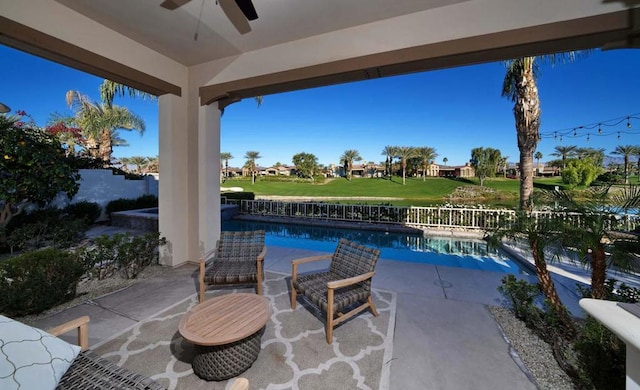 view of patio / terrace featuring ceiling fan and a fenced in pool