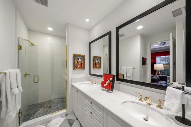 bathroom featuring a shower with shower door and vanity