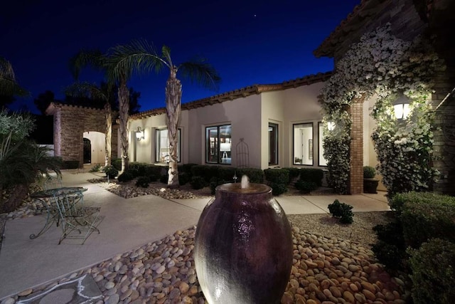 back house at night with a patio area