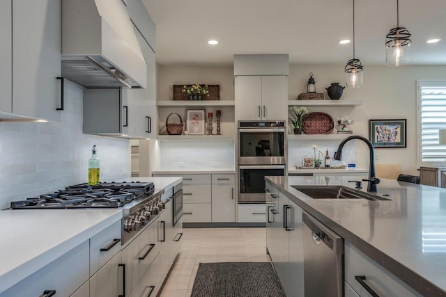 kitchen with decorative light fixtures, stainless steel appliances, decorative backsplash, sink, and custom range hood