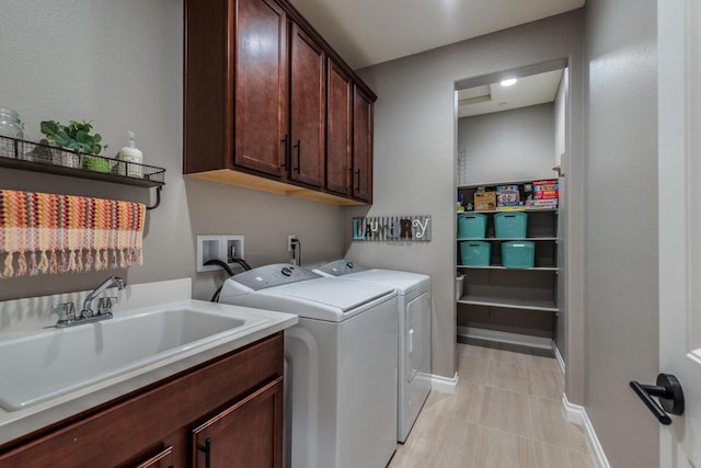 laundry room featuring cabinets, washing machine and clothes dryer, and sink