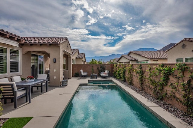 view of swimming pool featuring a mountain view and a patio