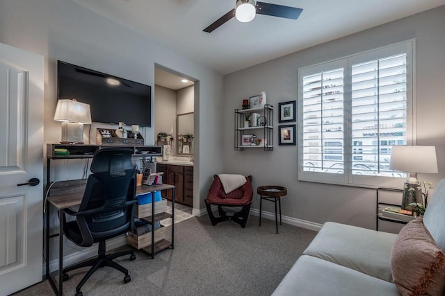 carpeted office space featuring ceiling fan