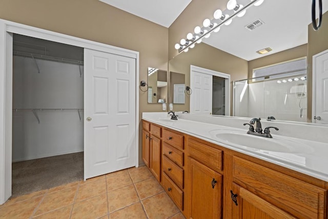 bathroom with a shower, tile patterned floors, and vanity