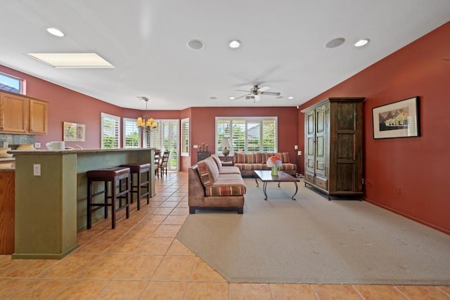 tiled living room featuring ceiling fan with notable chandelier