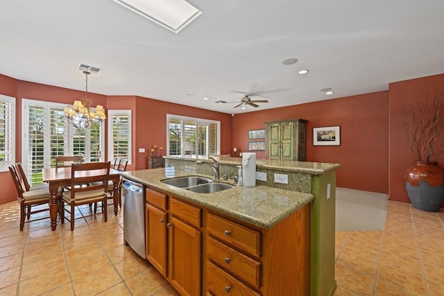 kitchen with a center island with sink, dishwasher, a wealth of natural light, pendant lighting, and sink