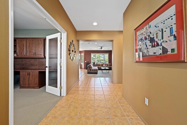 corridor with light colored carpet and french doors