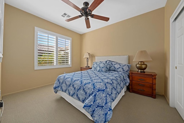 carpeted bedroom featuring ceiling fan and a closet