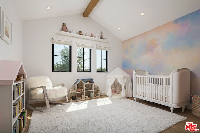 bedroom with dark hardwood / wood-style flooring, lofted ceiling with beams, and a crib