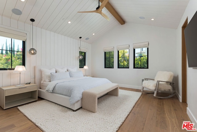 bedroom featuring ceiling fan, wood-type flooring, and vaulted ceiling with beams