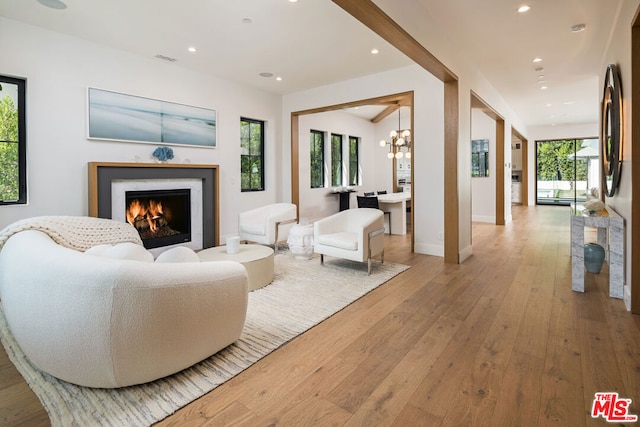 living room featuring light hardwood / wood-style flooring and an inviting chandelier