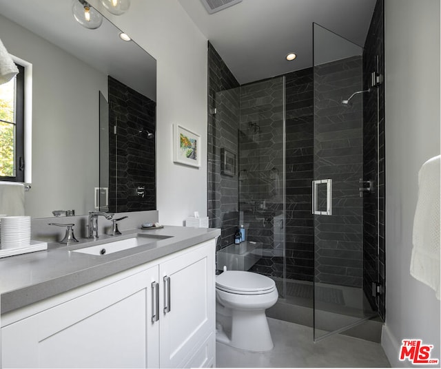 bathroom featuring toilet, vanity, and walk in shower