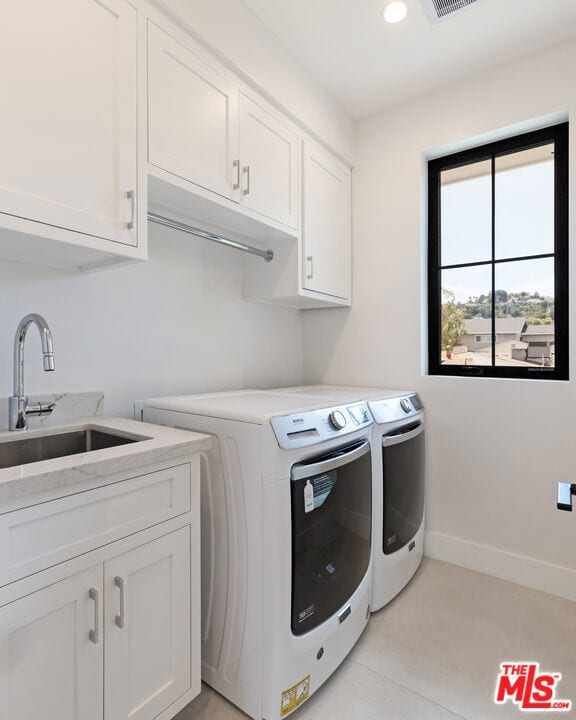 laundry room with cabinets, sink, and washing machine and clothes dryer