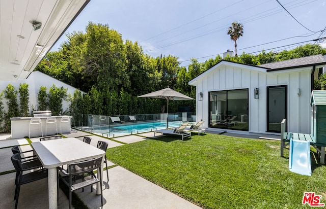 view of swimming pool with a yard, a patio, and an outdoor structure