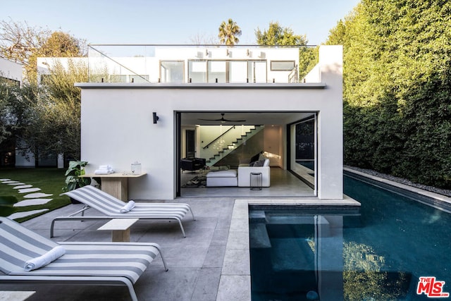 back of property with ceiling fan and a patio