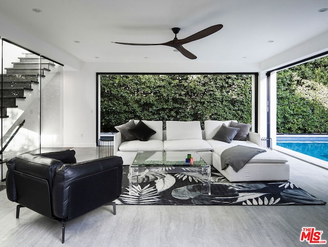 living room featuring ceiling fan and a wealth of natural light