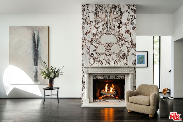 sitting room with a high end fireplace and dark hardwood / wood-style floors