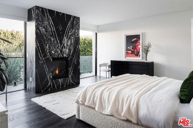 bedroom featuring a high end fireplace and dark wood-type flooring