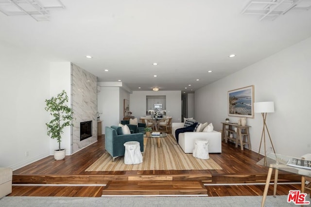 living room with a high end fireplace and hardwood / wood-style flooring