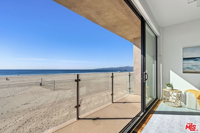 balcony with a water view and a beach view