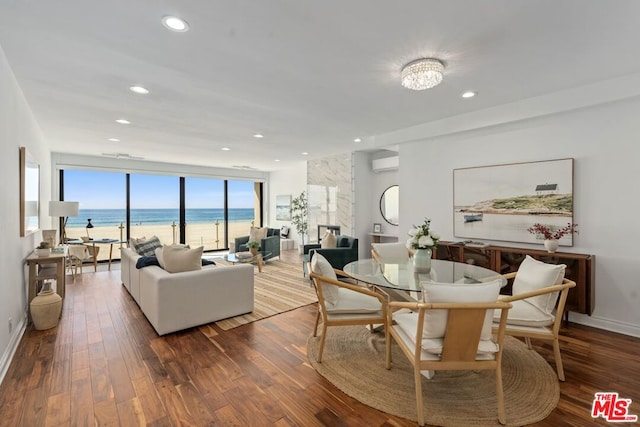 dining room with a chandelier, a water view, wood-type flooring, and an AC wall unit