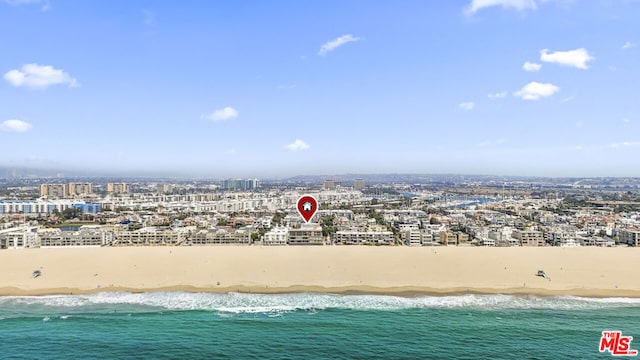 birds eye view of property with a water view and a beach view