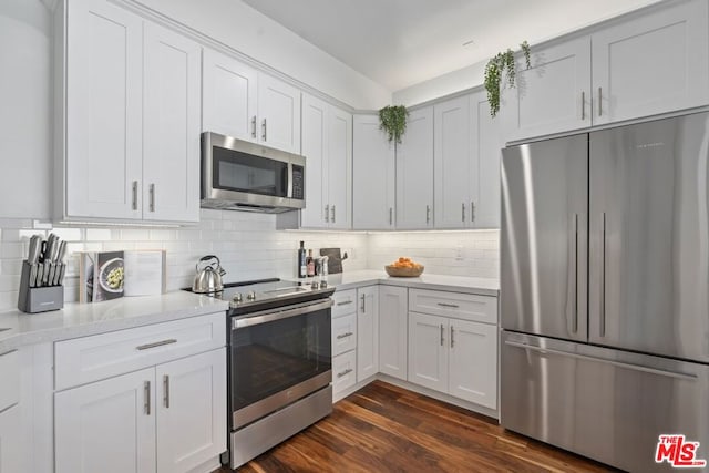 kitchen with backsplash, white cabinets, dark hardwood / wood-style floors, and stainless steel appliances