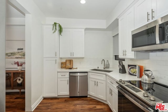 kitchen with white cabinets, decorative backsplash, sink, and stainless steel appliances