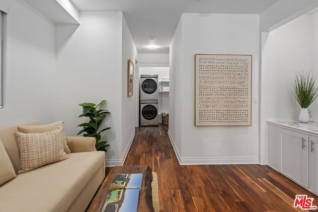 hall featuring dark hardwood / wood-style flooring and stacked washer and clothes dryer