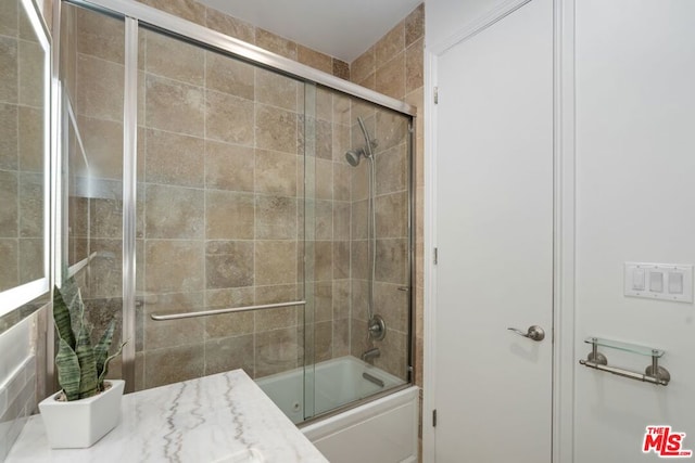 bathroom featuring shower / bath combination with glass door and vanity