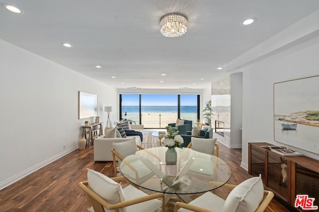 dining area featuring a water view, dark hardwood / wood-style flooring, and a chandelier