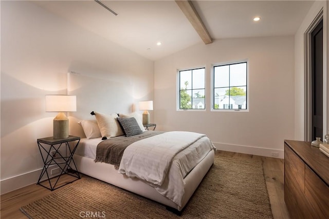 bedroom featuring hardwood / wood-style flooring and lofted ceiling with beams