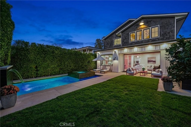 back house at dusk with a swimming pool with hot tub, outdoor lounge area, a yard, and a patio