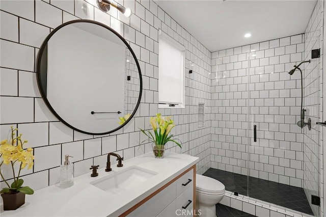 bathroom with a shower with door, vanity, backsplash, tile walls, and toilet