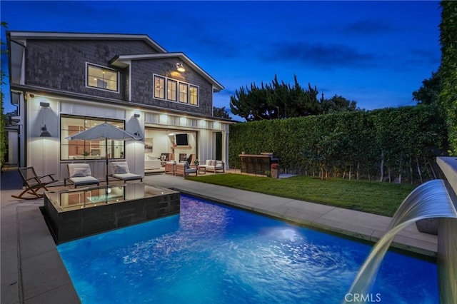 back of house with a lawn, pool water feature, a fenced in pool, an outdoor living space, and a patio