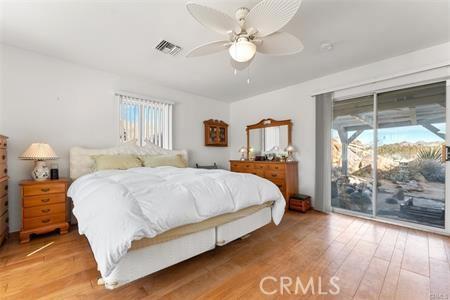 bedroom featuring ceiling fan, access to exterior, and wood-type flooring