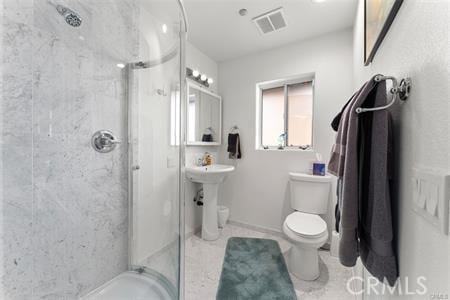 bathroom with toilet and a tile shower