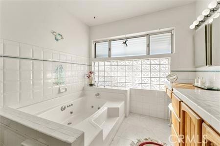 bathroom with tiled bath and vanity