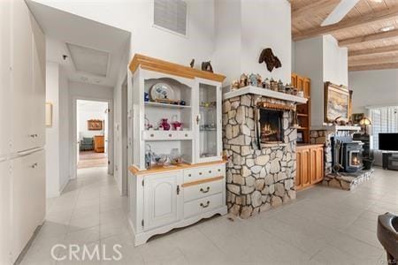 kitchen featuring a high ceiling, white cabinets, wood ceiling, beamed ceiling, and ceiling fan