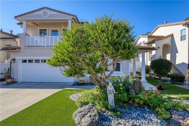 view of front of home featuring a garage, a front lawn, and a balcony