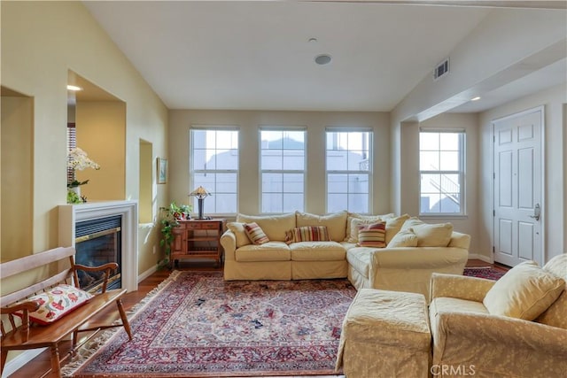 interior space with a healthy amount of sunlight, visible vents, wood finished floors, and a glass covered fireplace